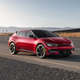 A red 2023 Kia EV6 GT is parked on a desert road.